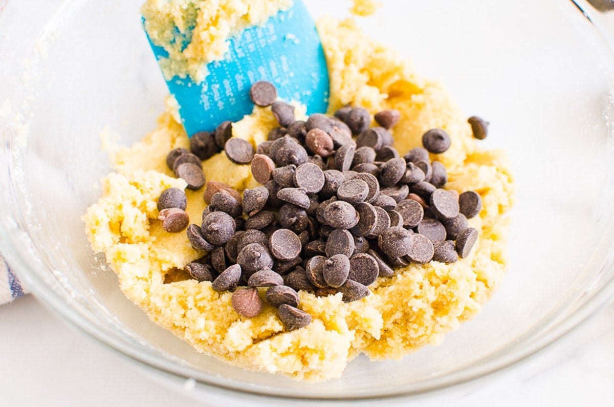 Chocolate chips in a bowl of cookie dough.