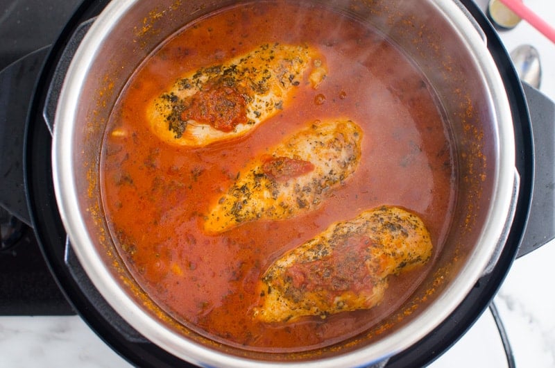 Chicken breast in Instant Pot with red sauce.