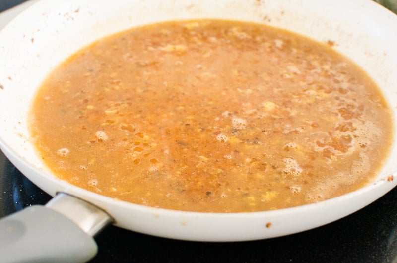 Deglazing skillet with lemon butter sauce.