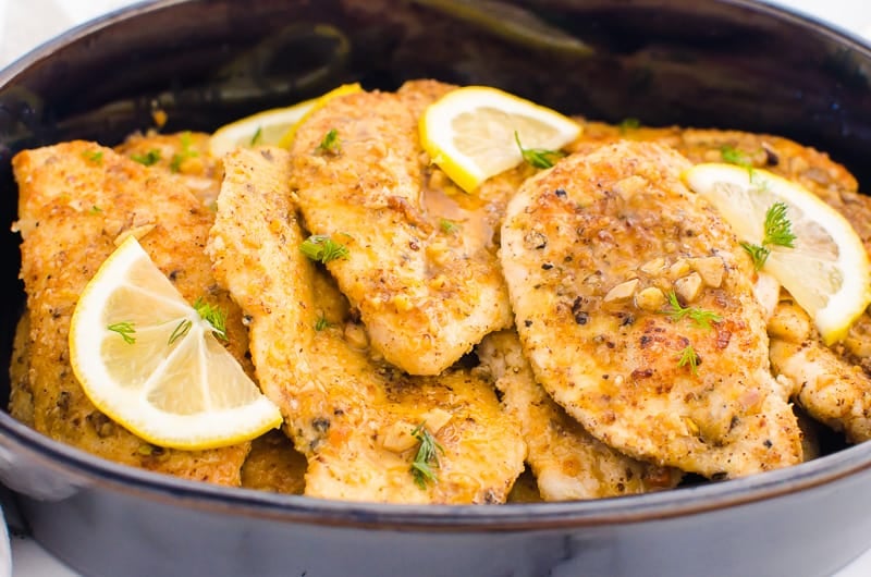 lemon chicken in a baking dish garnished with lemon slices