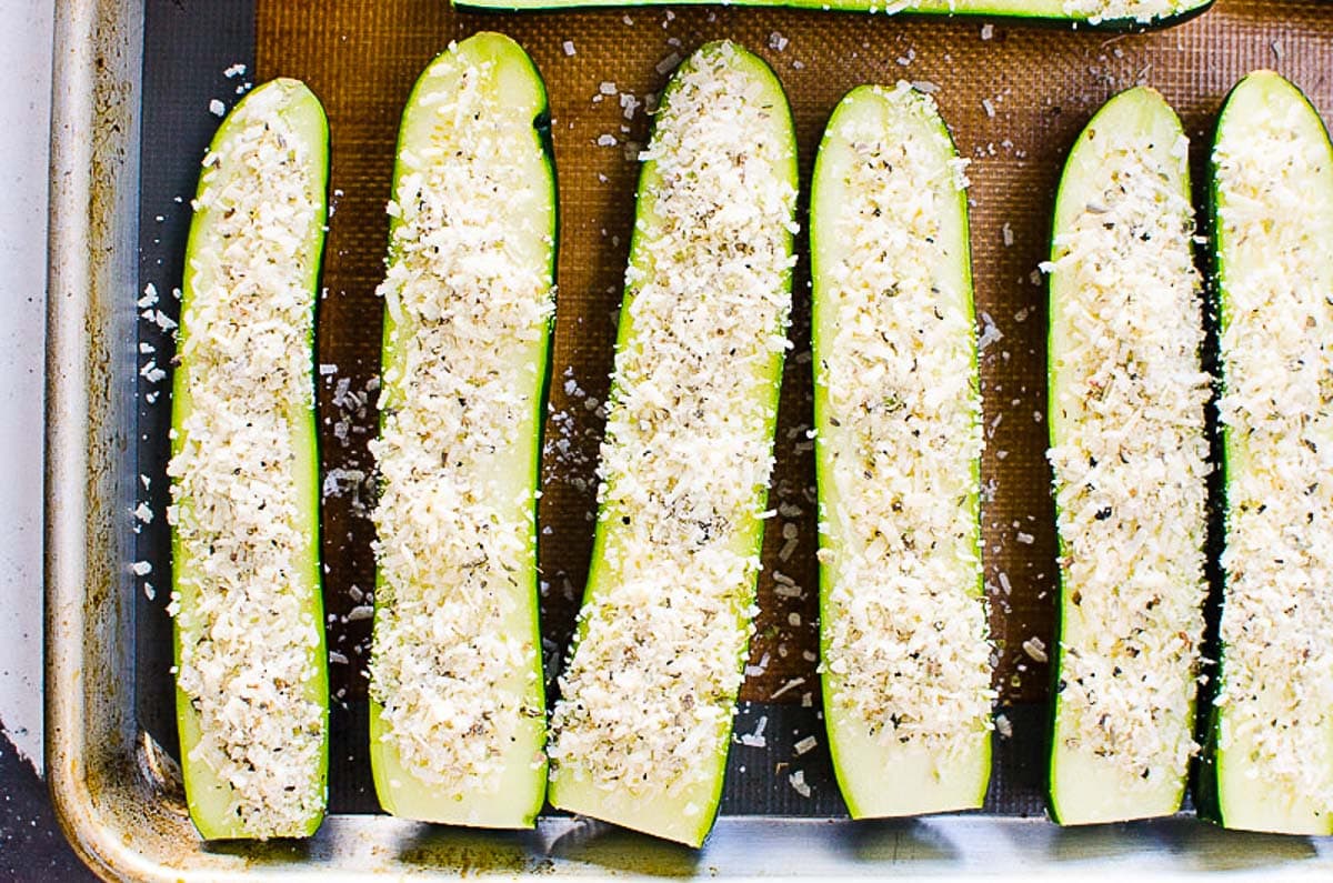 Zucchini halves sprinkled with cheese and herbs.