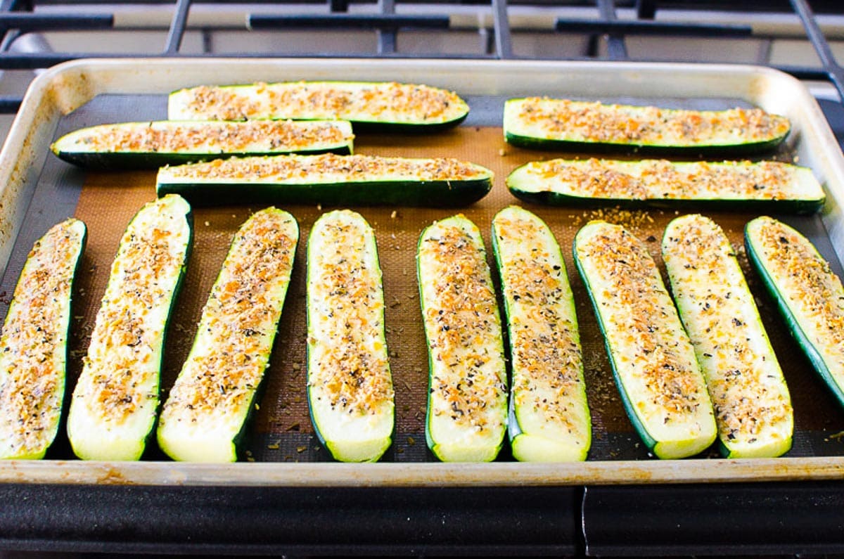 Parmesan zucchini sticks baked on a baking sheet.