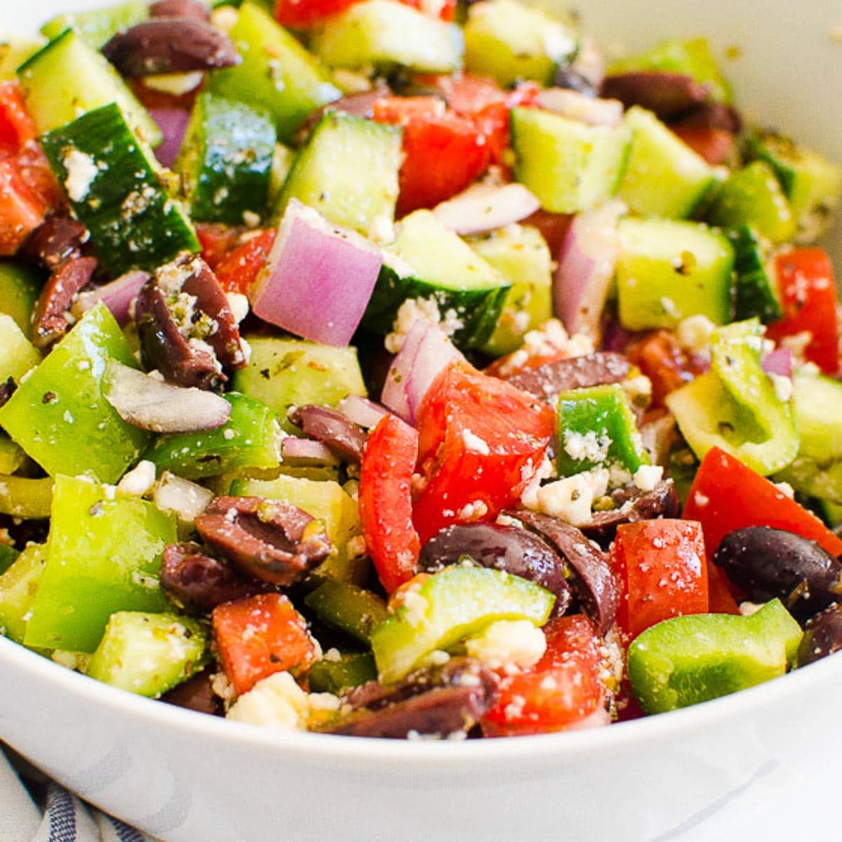 Traditional Greek salad in a white bowl.