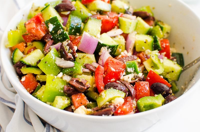 greek salad in a bowl with spoon