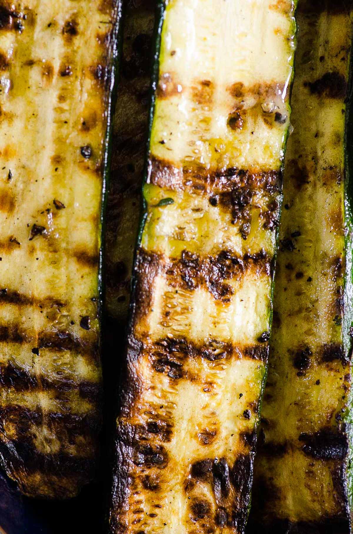 Closeup of grilled zucchini slice coated in garlic oil.