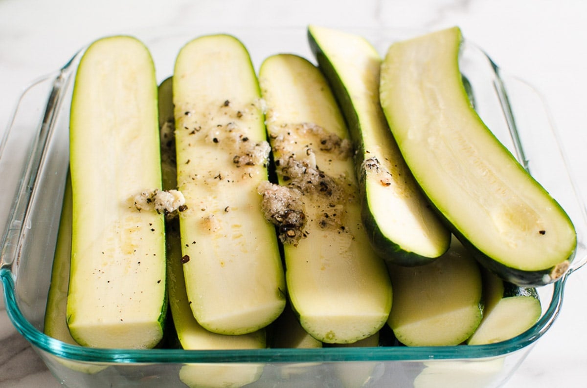 Raw zucchini slices drizzled with oil and seasoned with salt, pepper and garlic.