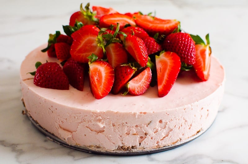 Whole no bake healthy strawberry cheesecake topped with fresh strawberries on top.