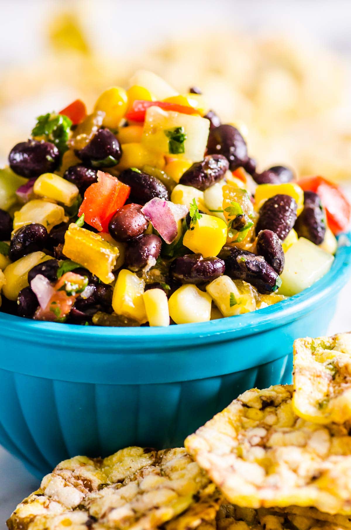 Black bean and corn salsa in a blue serving bowl with whole grain chips.