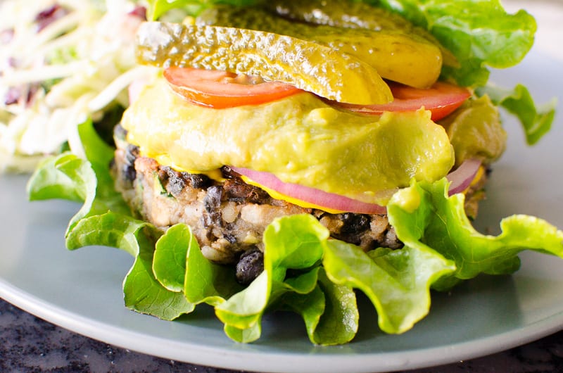 Black Bean Burger wrapped in lettuce and topped with guacamole, red onion, tomato and avocado