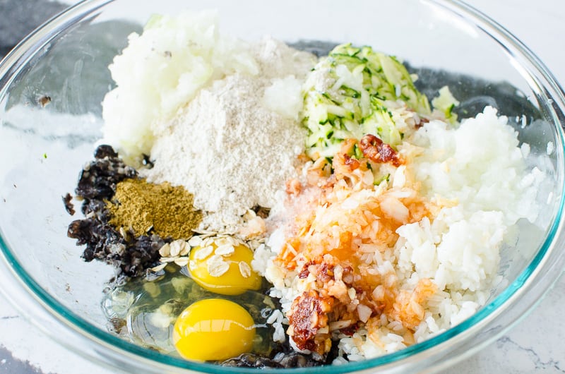 black beans, rice, eggs, zucchini, flour and spices in a glass bowl