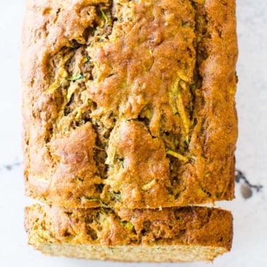 Healthy zucchini banana bread loaf with a slice cut off at the end.