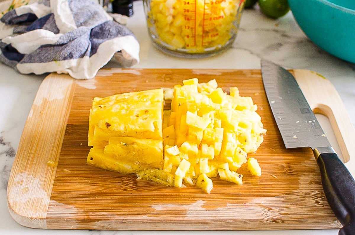 Diced pineapple on a cutting board.
