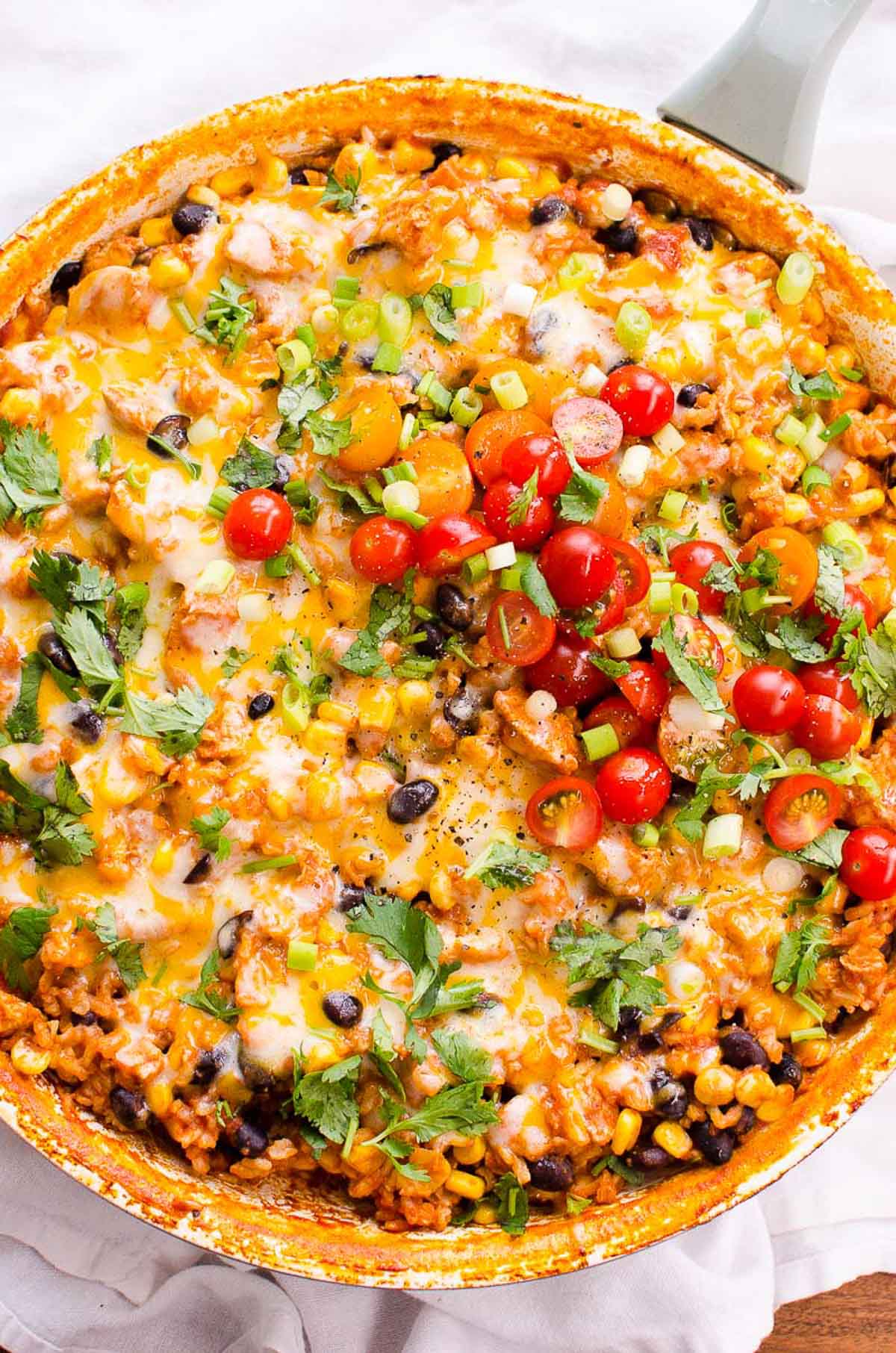 Chicken burrito skillet garnished with cilantro and tomatoes.