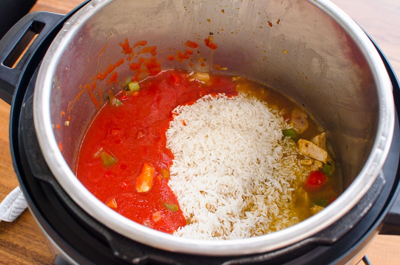 Instant Pot Jambalaya ingredients showing rice and tomato sauce before cooking