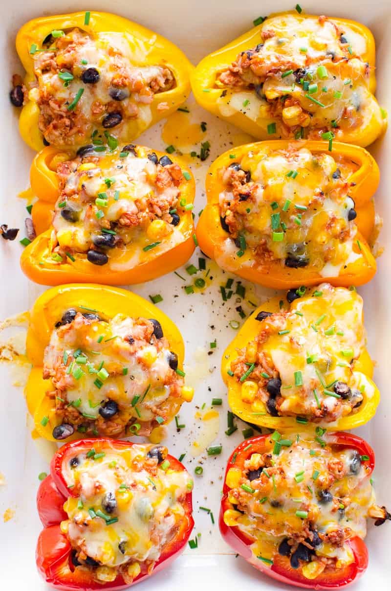 8 Mexican Stuffed Peppers in white dish garnished with green onions