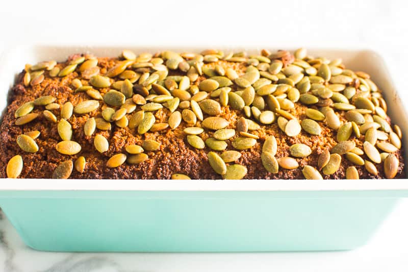 Almond flour pumpkin bread in light blue loaf pan topped with pumpkin seeds