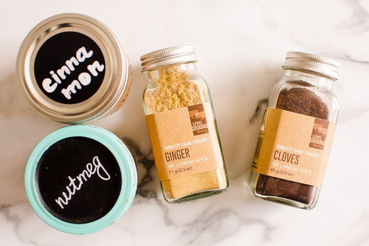 Cinnamon, nutmeg, cloves, ginger in glass jars with lids.