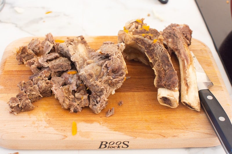 Cooked beef bones on cutting board.