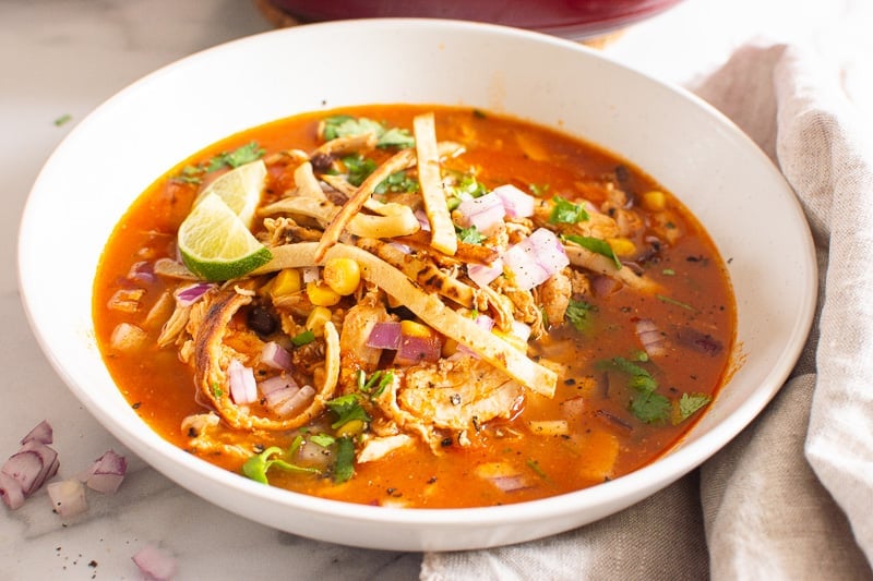 bowl of chicken tortilla soup garnished with tortilla strips