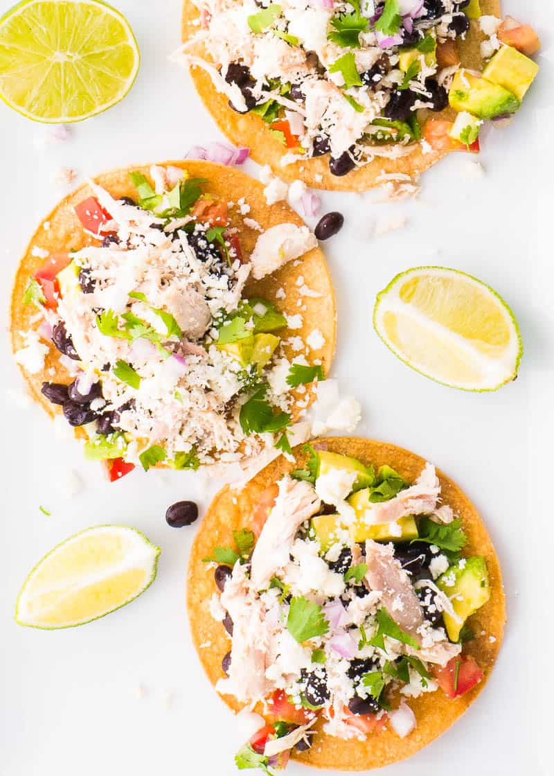 Three chicken tostadas with toppings and ready to eat.