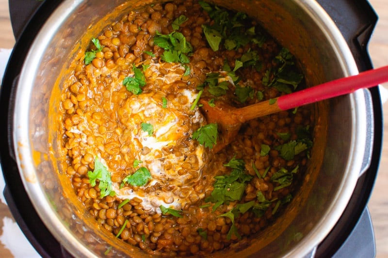 instant pot dal in the pressure cooker ready to eat garnished with cilantro and yogurt