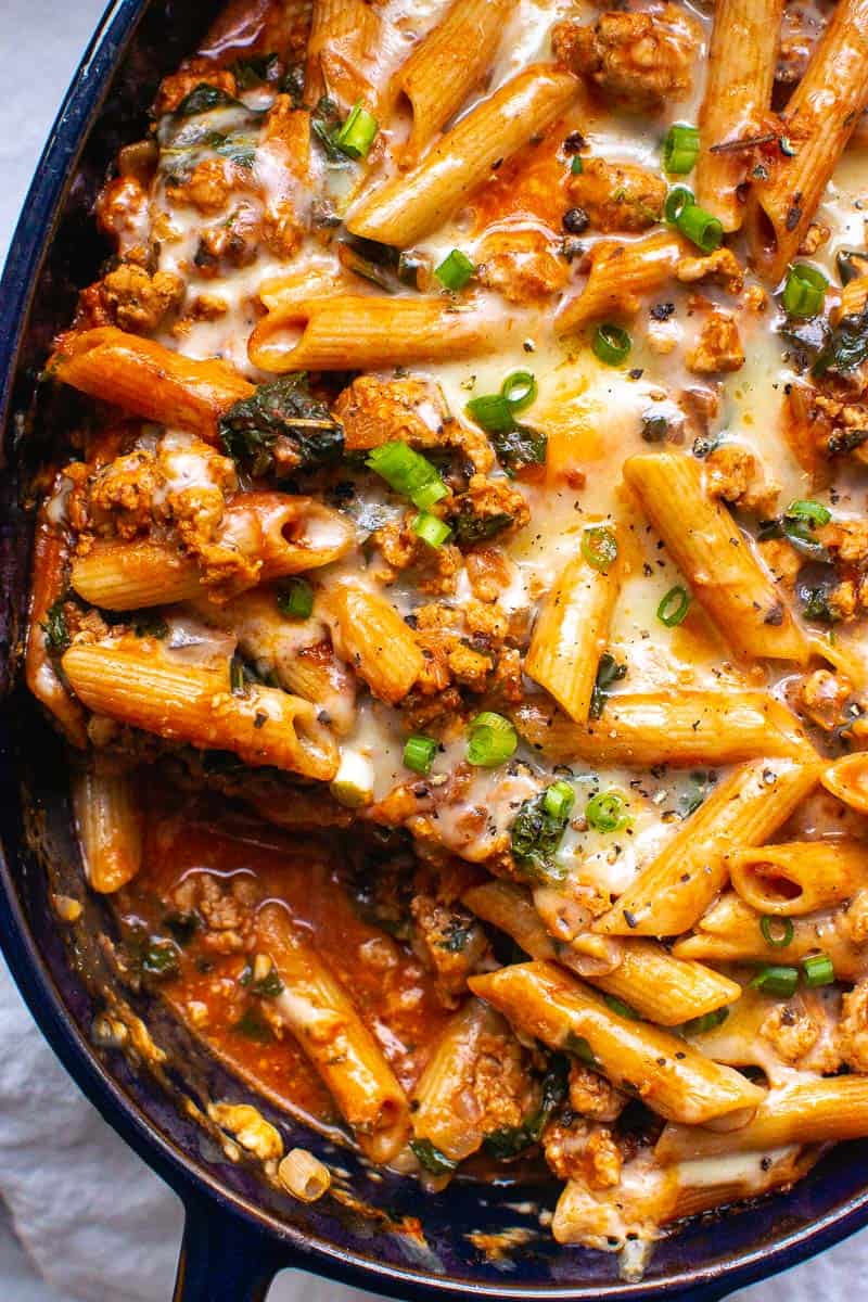 Pasta with ground turkey casserole with melted cheese and green onions on top.
