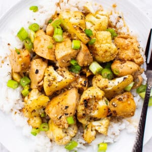 Teriyaki chicken and cauliflower on a plate with white rice.