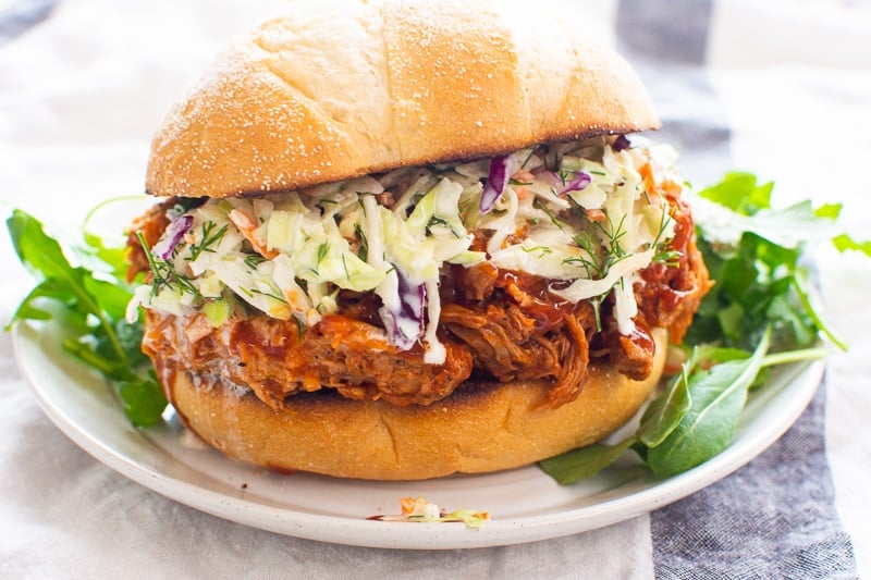 Instant Pot pulled pork on a sandwich bun with coleslaw.