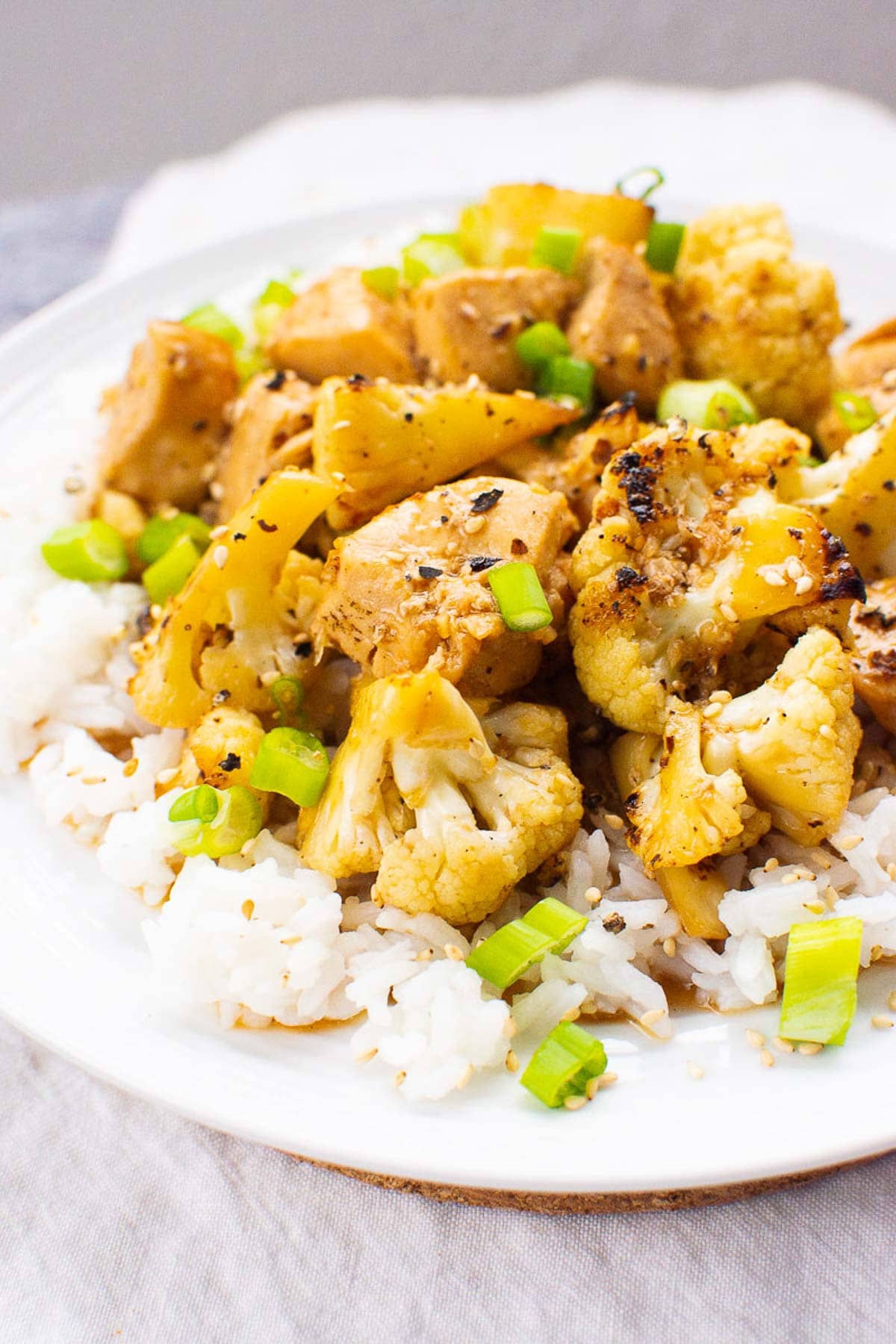 Teriyaki chicken and cauliflower over white rice and garnished with green onion.