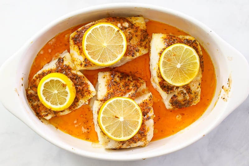 overhead image of baked lemon butter cod in a white baking dish