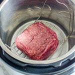 Instant Pot frozen ground beef on trivet in Instant Pot.