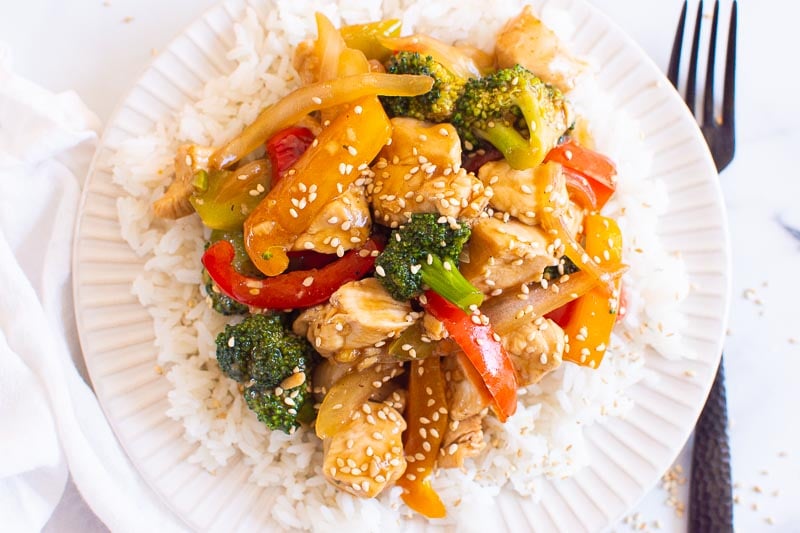 plate of chicken stir fry served over white rice