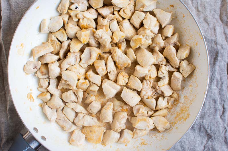 cubed chicken cooked in white skillet