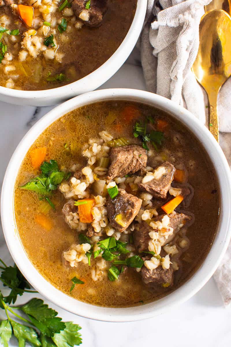 Instant Pot Beef Barley Soup in white bowl garnished with parsley