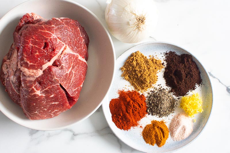 sirloin tip roast, spices on a plate and white onion