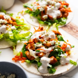 Buffalo chicken tacos drizzled with blue cheese dressing.