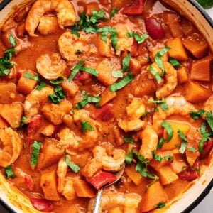 Thai shrimp curry garnished with cilantro in a skillet.