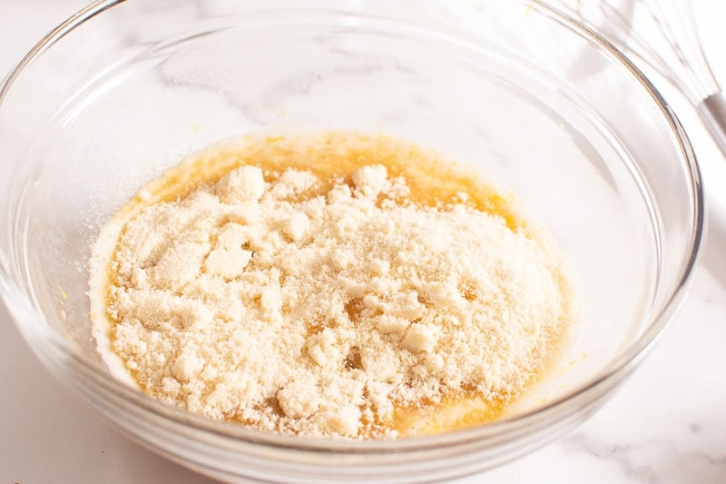almond flour added to wet ingredients in glass bowl