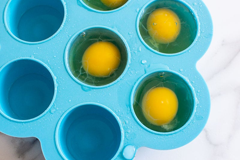 eggs cracked in molds filled with water