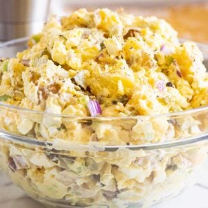 Instant Pot potato salad served in glass bowl and pepper mill behind on a counter.