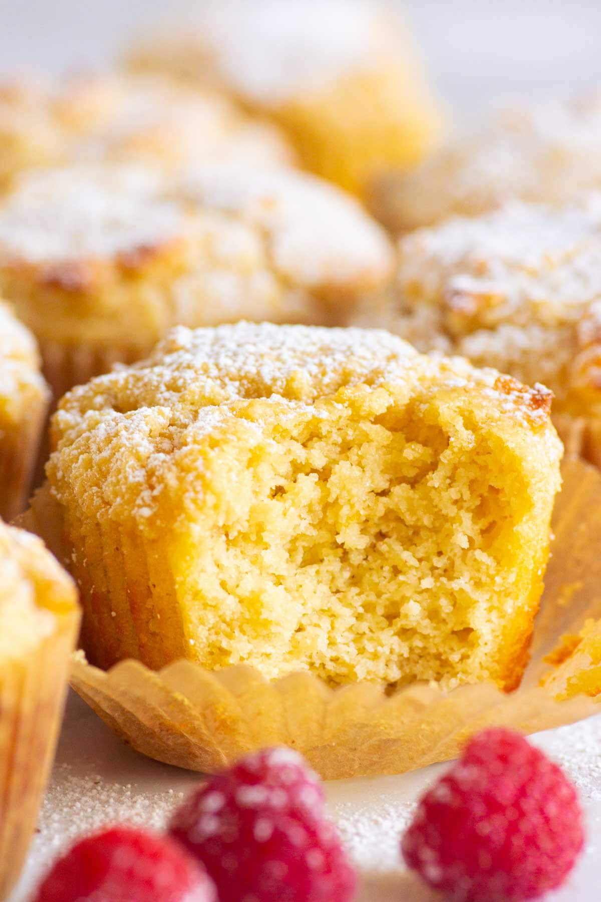 Almond flour yogurt muffins dusted with icing sugar and showing texture inside.