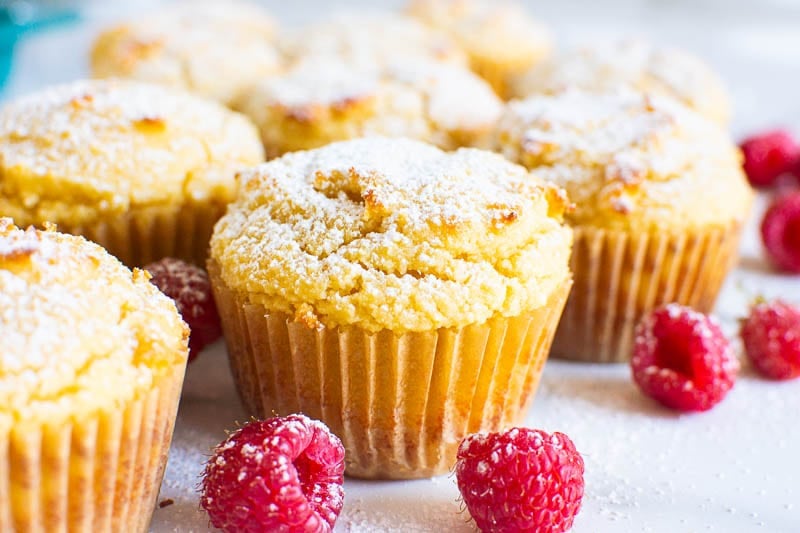 Gluten free muffins with icing sugar and raspberries.