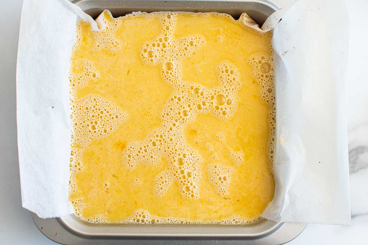 Lemon filling poured on top of crust in a baking dish.