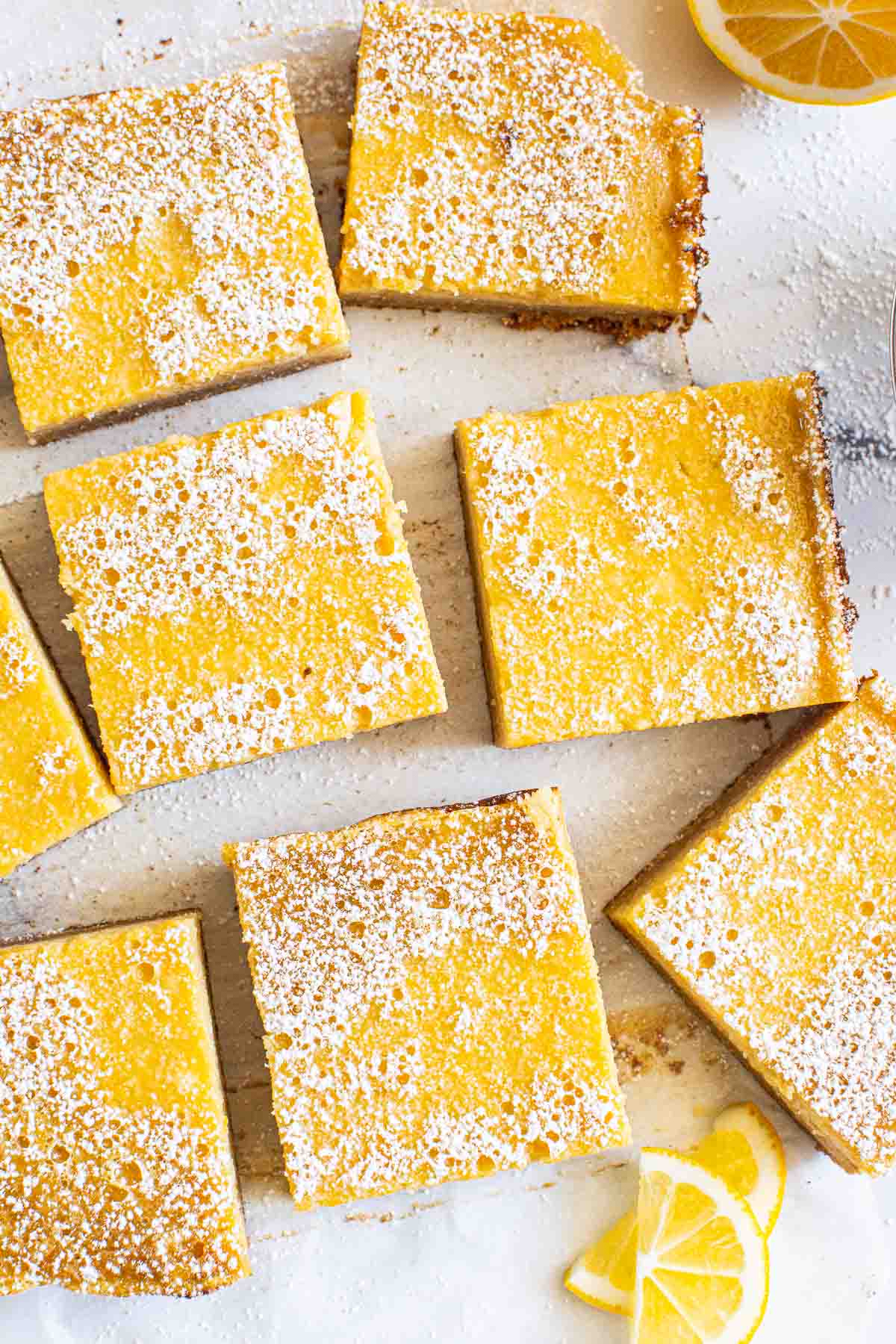 Healthy lemon bars dusted with icing sugar on a counter.