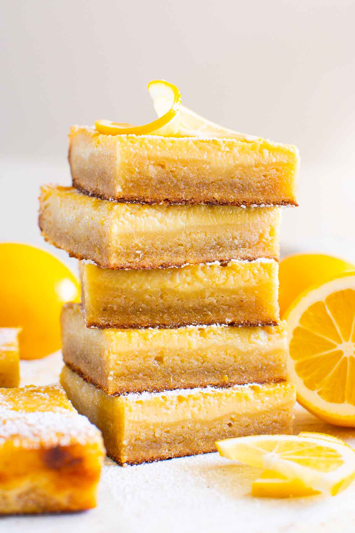 A stack of healthy lemon bars sprinkled with icing sugar.