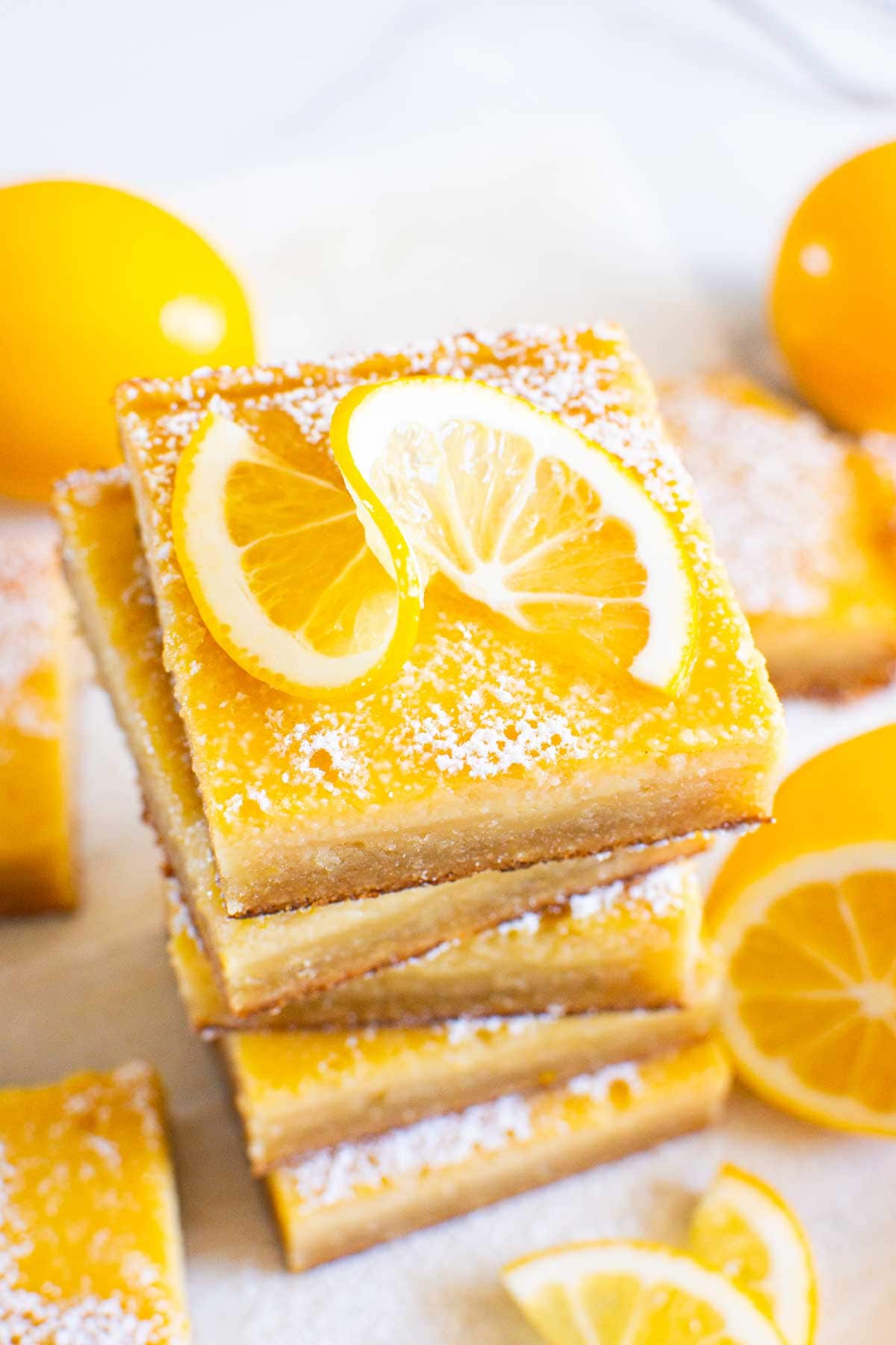 Healthy lemon bars stack garnished with lemon slice.