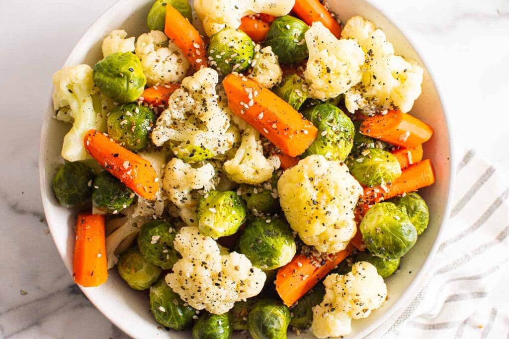 instant pot steamed vegetables with seasoning in white bowl