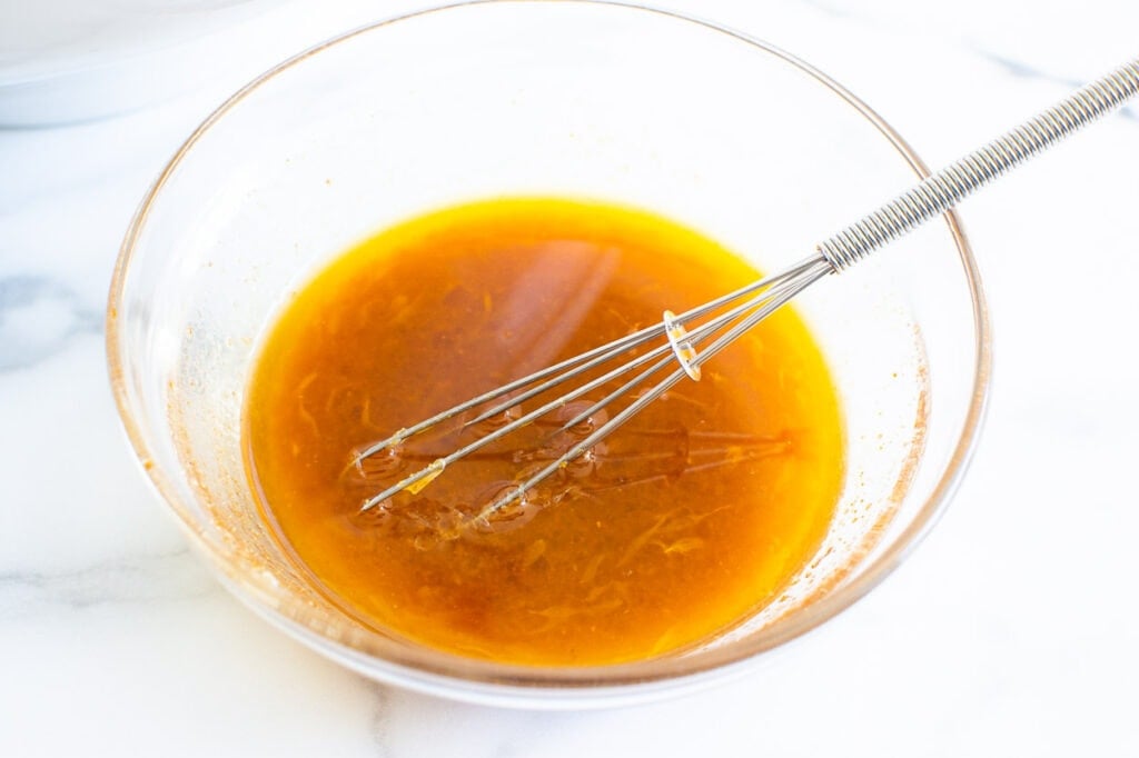 salad dressing in glass bowl with a whisk