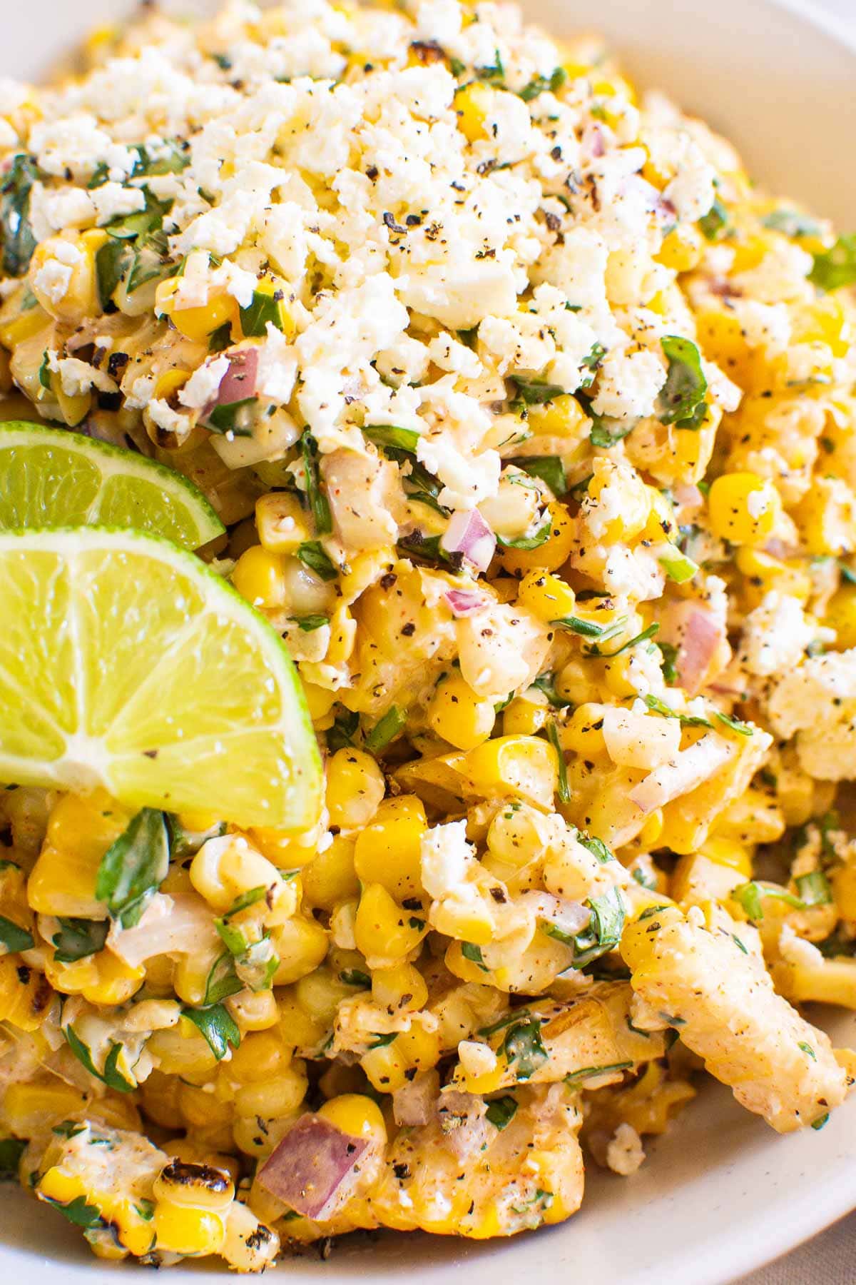 Healthy Mexican street corn salad recipe garnished with lime.