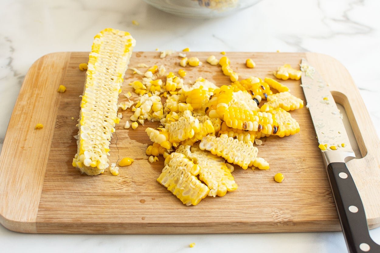 Cut off the cob corn on a cutting board with a knife.
